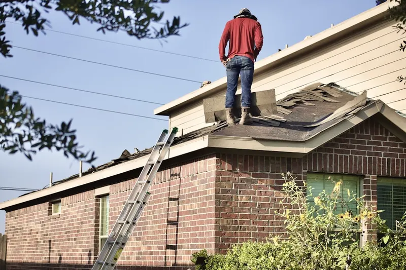 Professional roofer working on a residential roof in Windspray